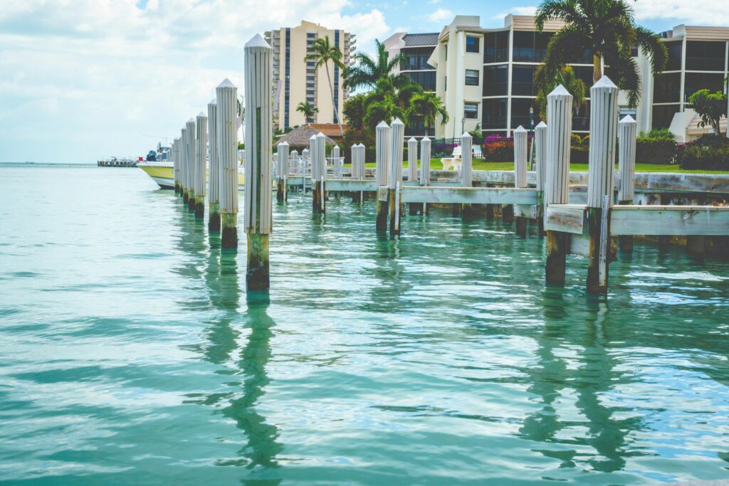 Luxurious waterfront marina with modern buildings and palm trees on Marco Island, Florida.